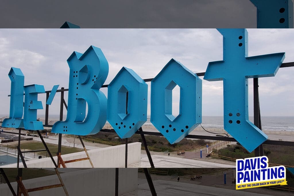 Large blue letters spell "Le Boot" on a rooftop sign against a cloudy sky. The background shows a boardwalk, beach, and ocean. The "Davis Painting" logo is in the bottom right corner.