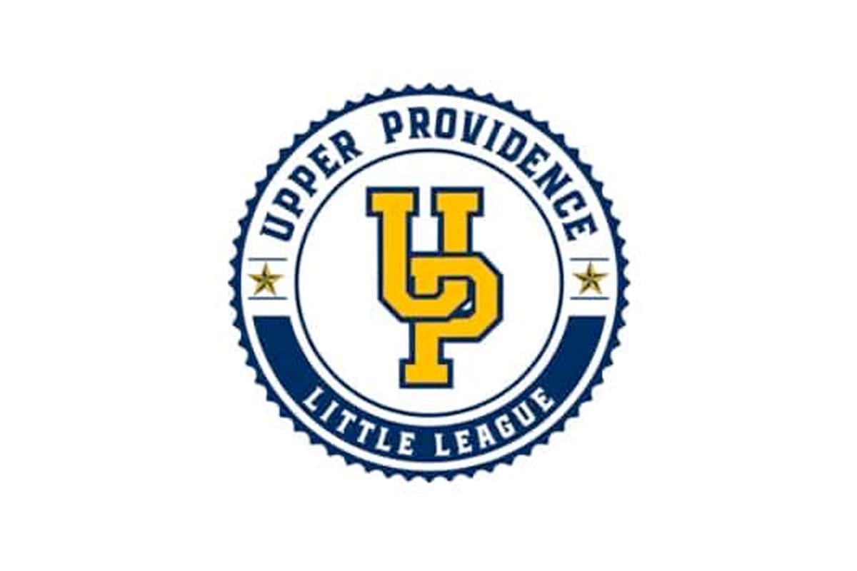 A circular logo with "Upper Providence Little League" written around the edge. In the center are the bold yellow letters "UP" outlined in blue, with two gold stars on either side.